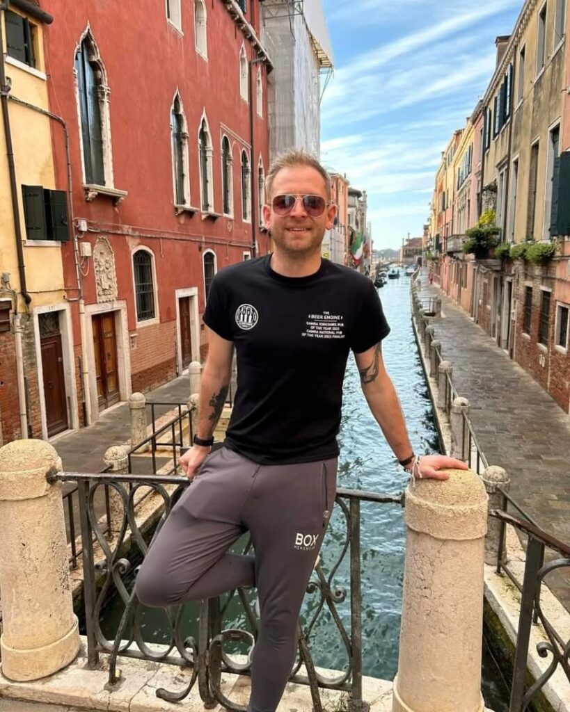 The Beer Engine x J Mitchell Design 2 Man wearing The Beer Engine Skipton t-shirt with front print, standing in Venice