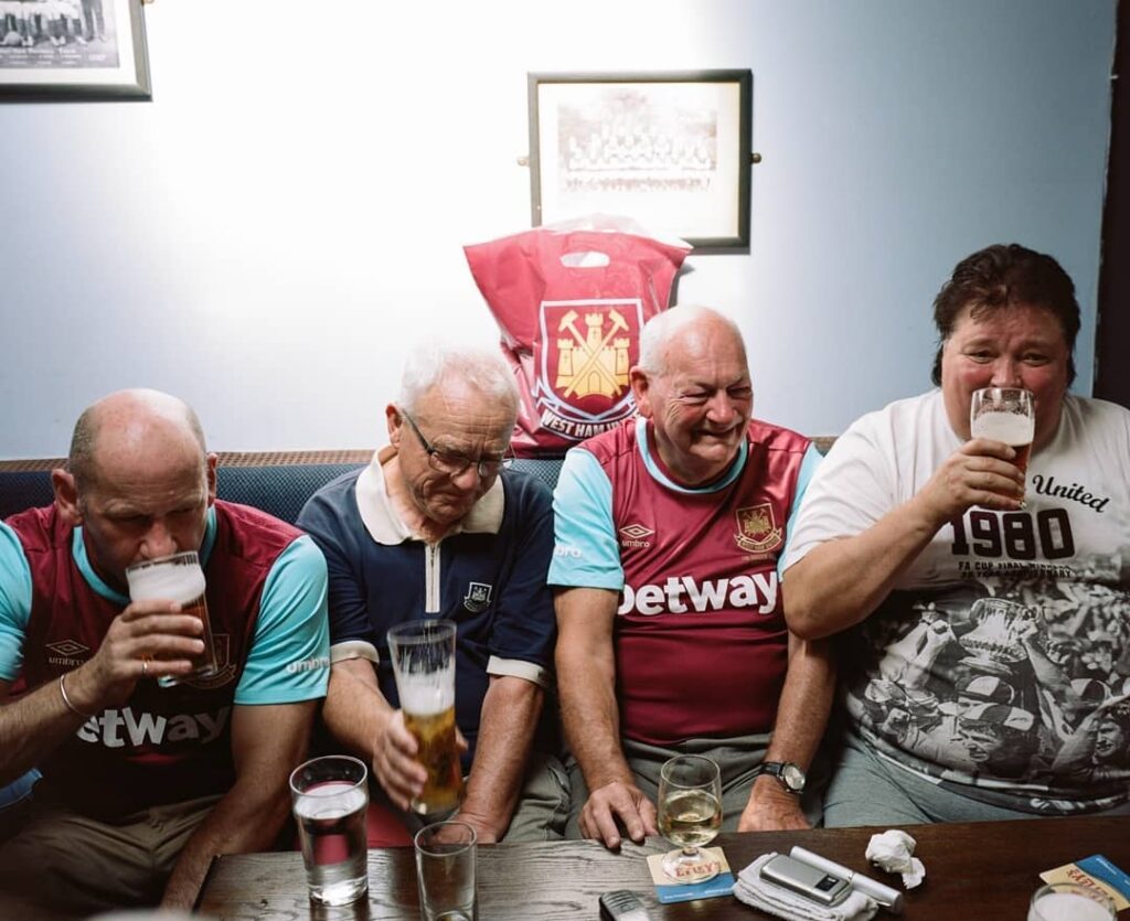 West Ham Fan Culture in Umbro Kits West Ham United fans wearing club kits, enjoying drinks together, designs by J Mitchell and the team at Umbro