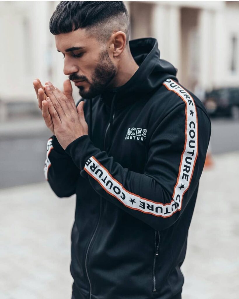 aces-couture-black-track-top-logo-tape Man in a black track jacket with branded sleeve tape by Aces Couture