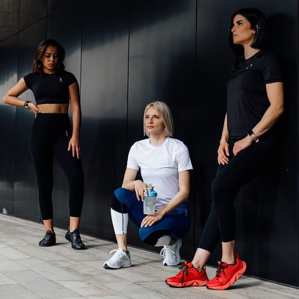 diva-activewear-group-black-white-blue Three women modelling Diva Activewear in black, white, and blue outfits