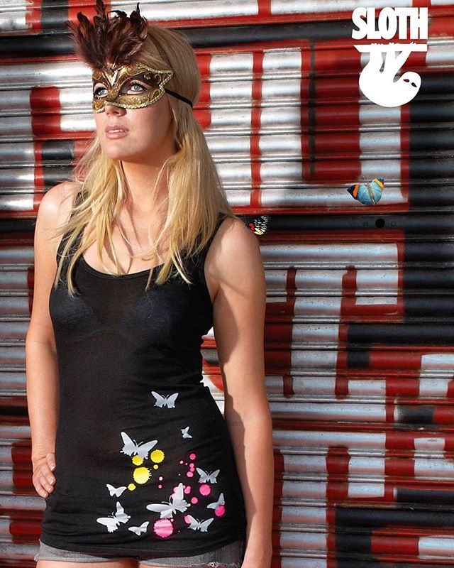 sloth clothing brighton womens streetwear design Model wearing a butterfly print vest top by Sloth Clothing in front of urban graffiti shutters
