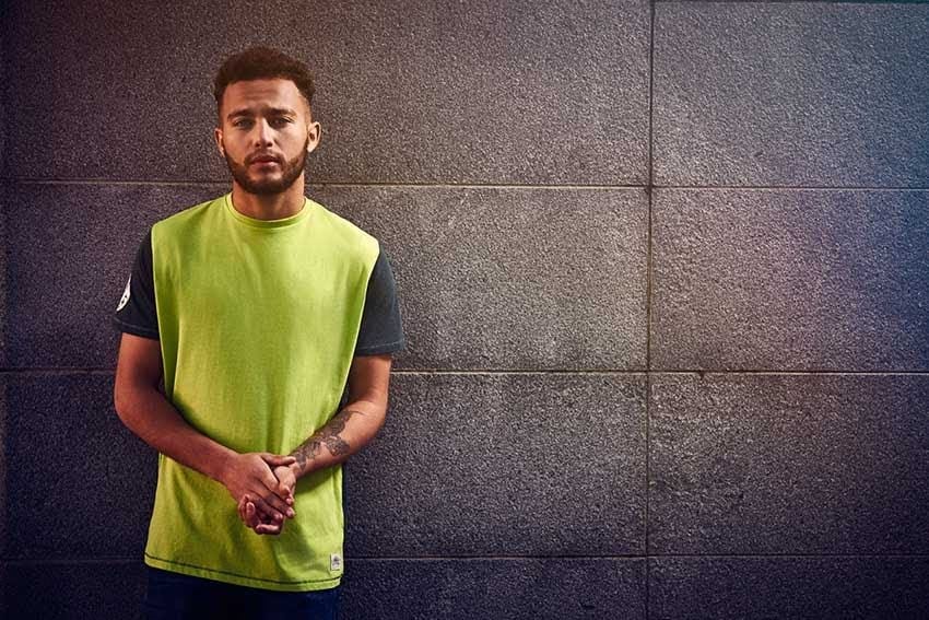 umbro-football-sportswear-fashion-designer Model in lime green and navy sportswear tee against concrete backdrop