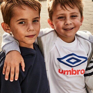 umbro-kids-sportswear-designer Two young boys smiling outdoors wearing Umbro T-shirts designed by Jonathan Mitchell, sold at Asda.