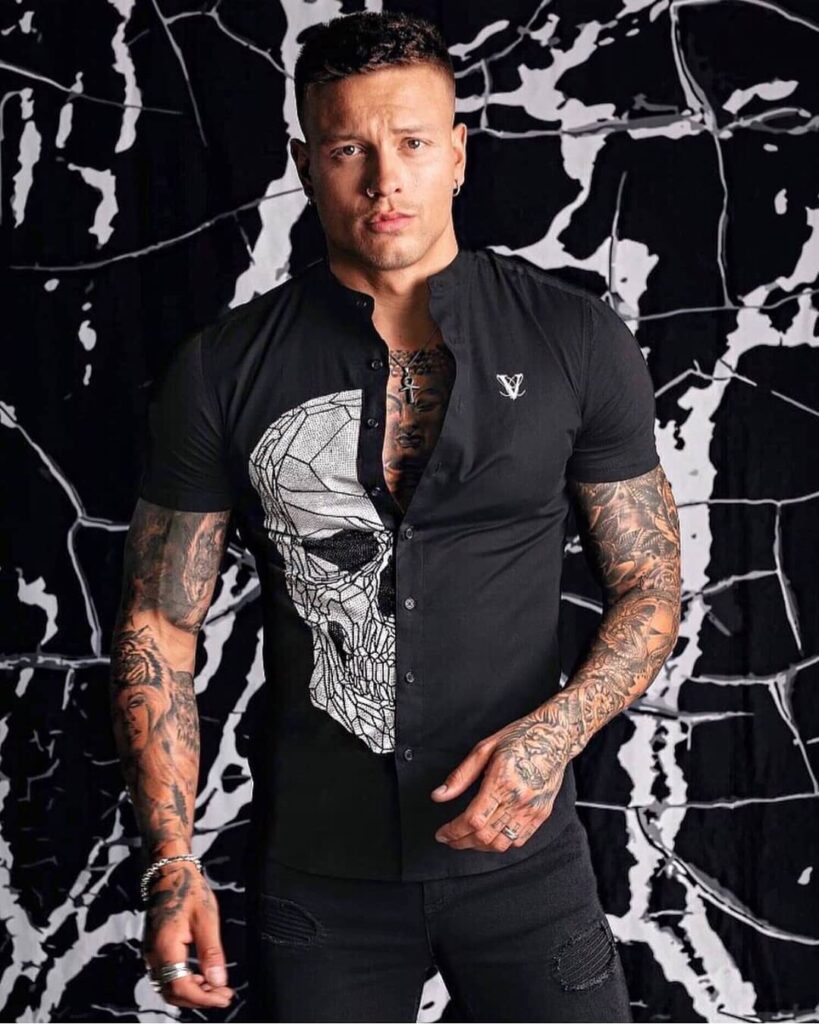 vole-la-lumiere-black-shirt-crystal-skull Man wearing black short sleeve shirt with crystal skull graphic and Volé La Lumière branding