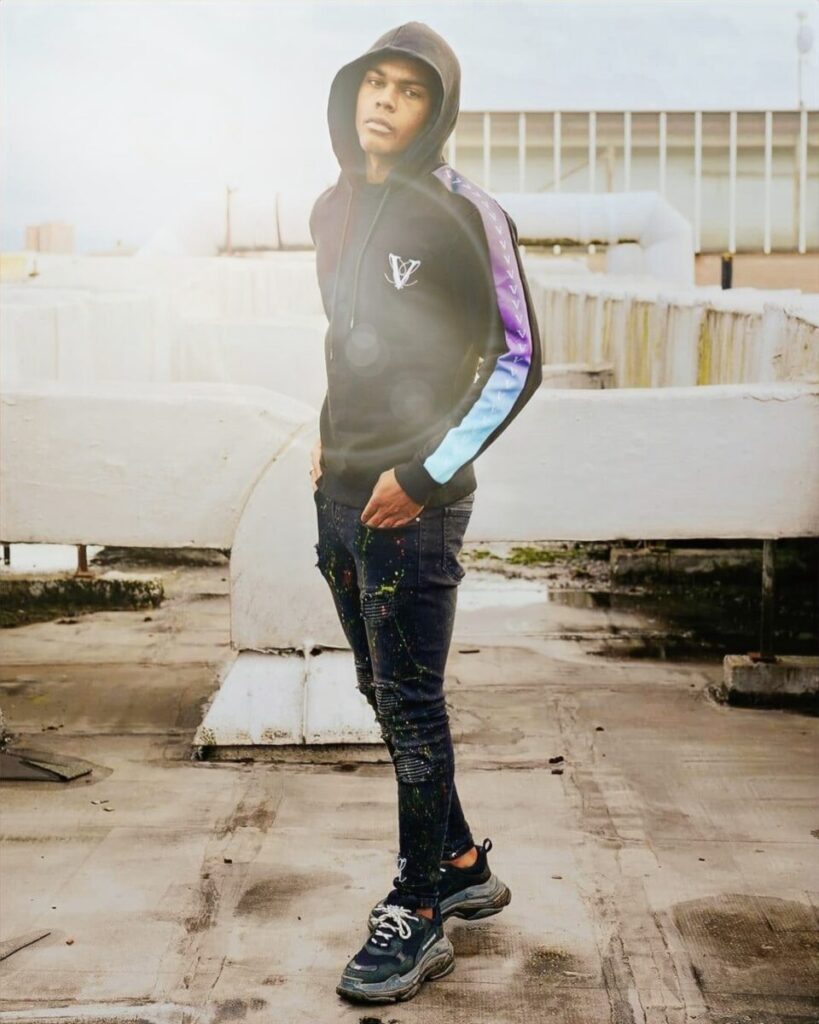 vole-la-lumiere-gradient-track-hoodie Man wearing black hoodie with gradient sleeve stripes and Volé La Lumière logo