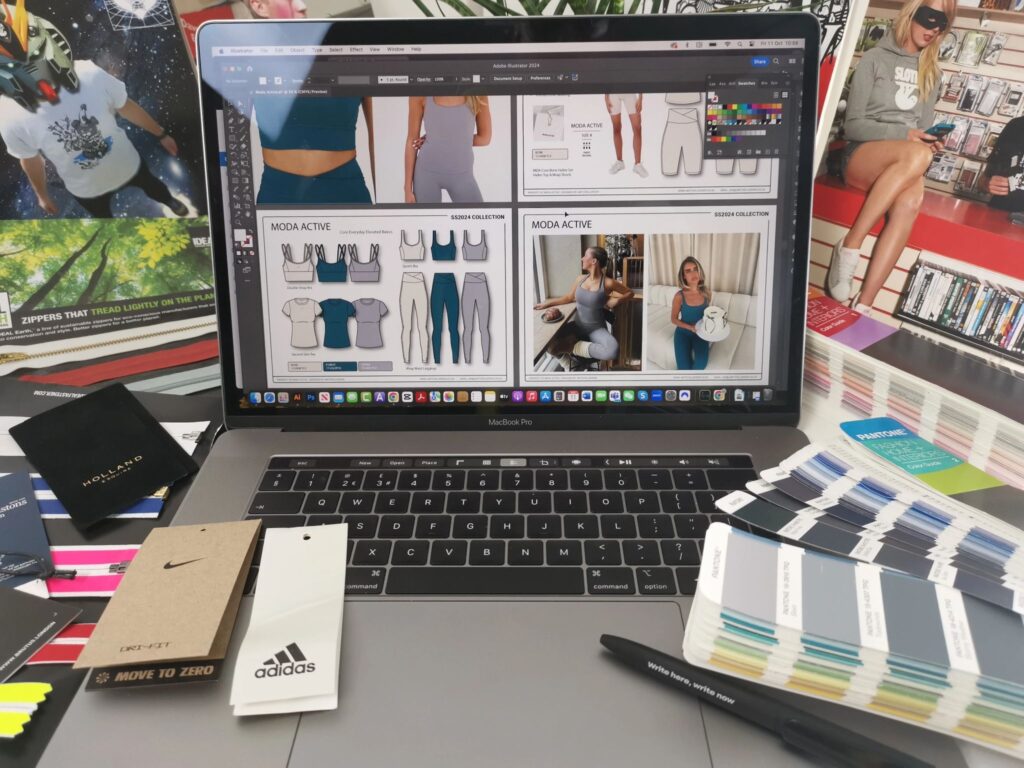 laptop with activewear designs showing on screen, sorrounded by oantone books and fashion inspiration