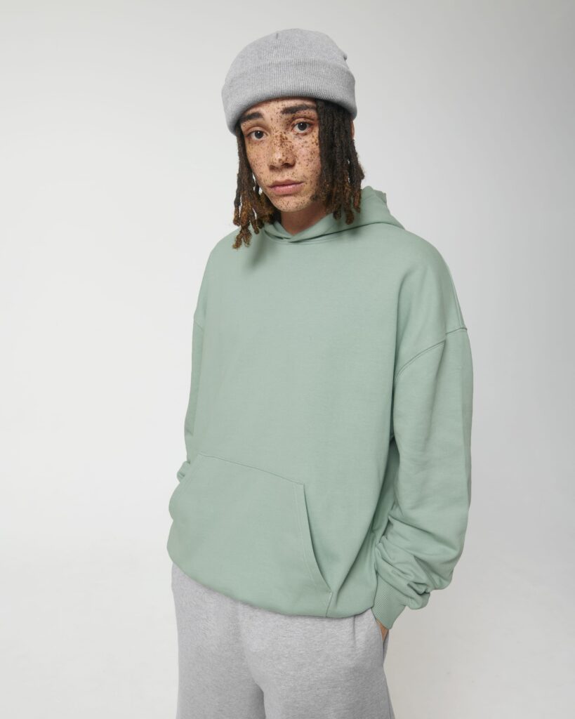 Stanley Stella hoodie – fashion design companies in UK Model wearing Stanley Stella oversized mint green hoodie and grey sweatpants – clothing designer company